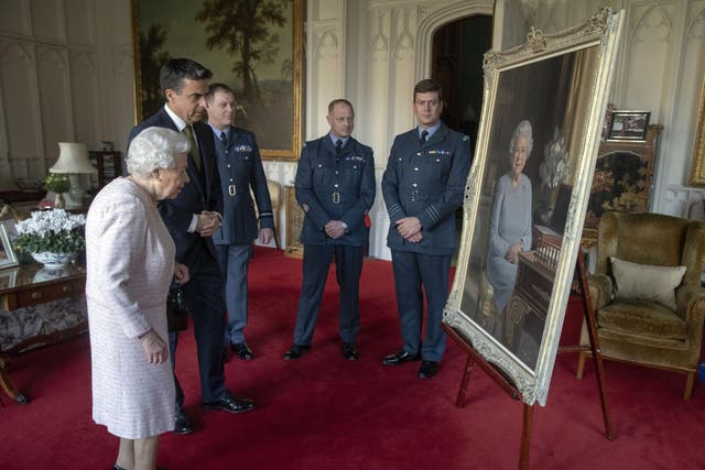 The Queen inspects a new portrait of herself at Windsor Castle last year