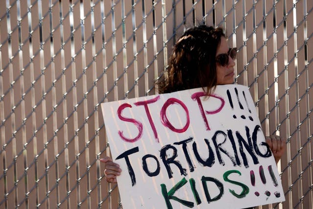 An activist holds a placard as she protests against the detention of immigrant children in detention centers