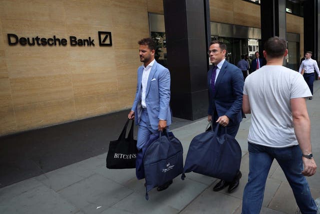 Tailors carrying suit bags leave Deutsche Bank office in London