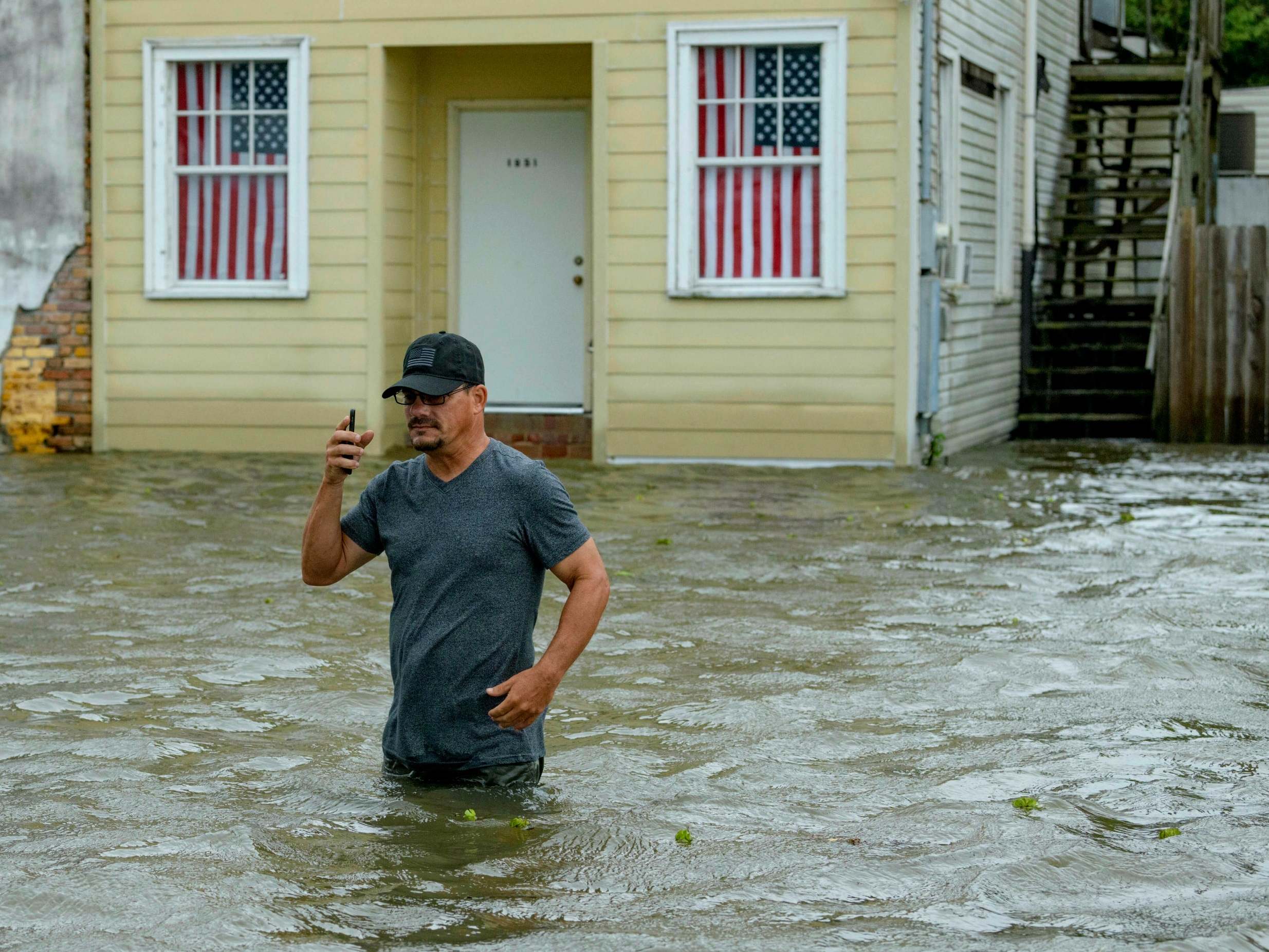 Barry Williams wades through a storm surge from Lake Pontchartrain in Mandeville, Louisiana