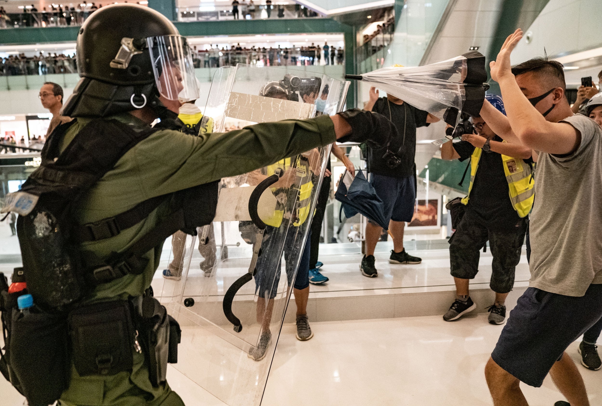 Riot police chase protesters through a shopping mall as they clashed on Sunday