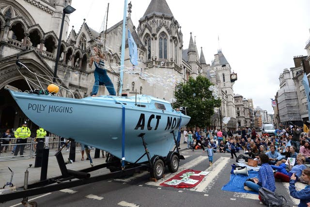 Protesters from Extinction Rebellion with a boat that they have parked outside the Royal Courts of Justice in London