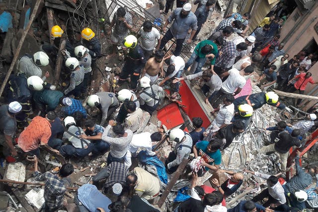 Rescue workers and residents search for survivors at the site of a collapsed building in Mumbai, India,