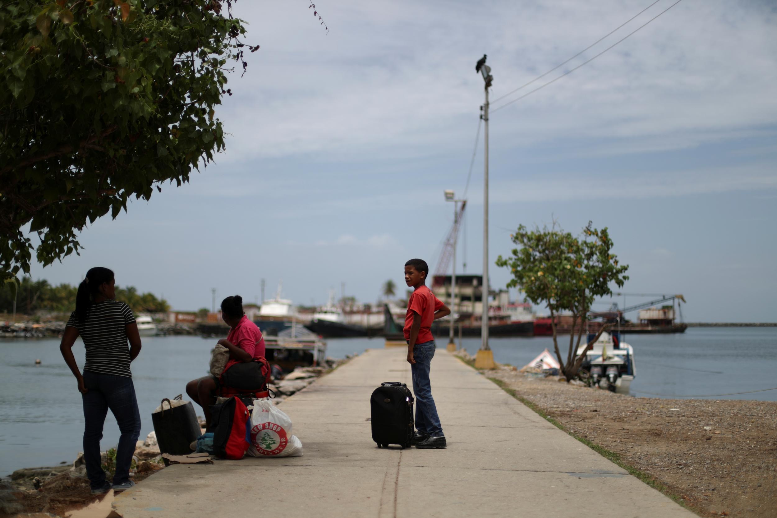 Local residents wait for a boat in a dock at Guiria, Venezuela (Reuters)