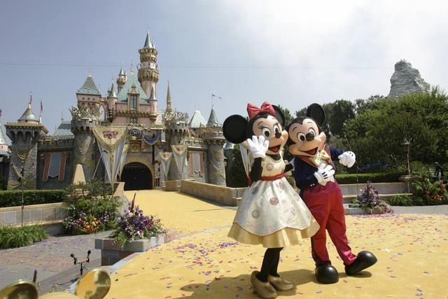 Disney characters Mickey Mouse and Minnie in front of the Sleeping Beauty Castle at Disneyland in Anaheim, California.