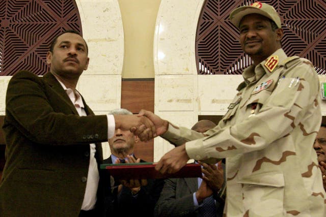Sudanese deputy chief of the ruling military council and protest movement leader shake hands after inking an agreement
