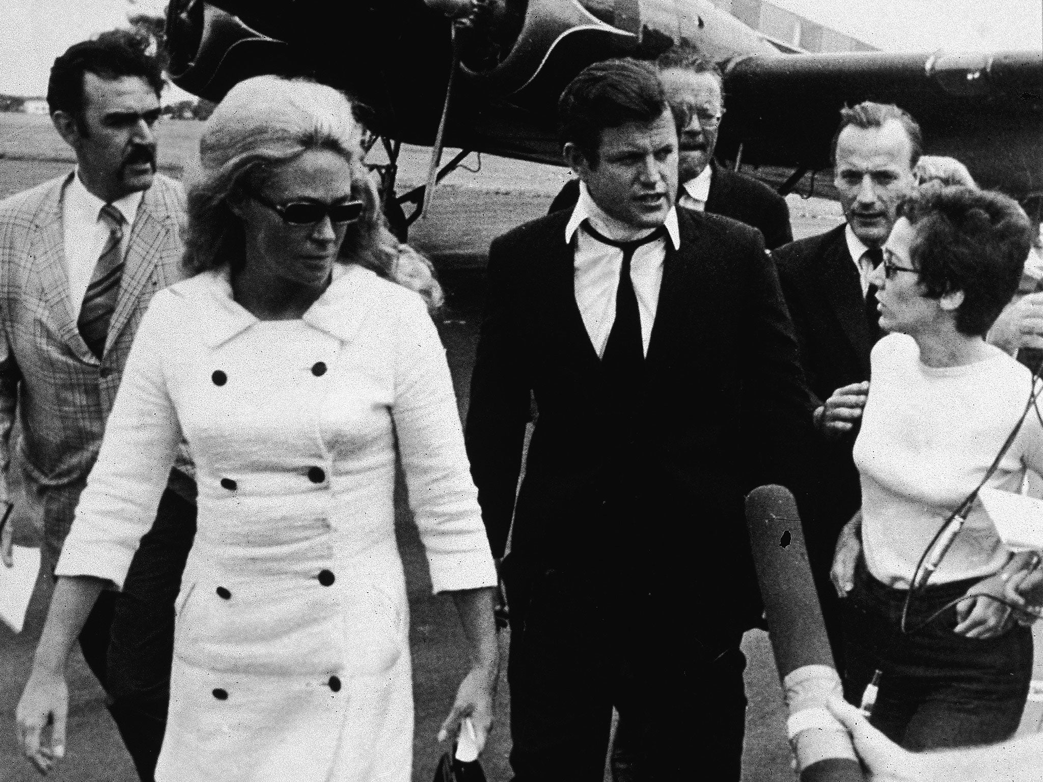 Kennedy, wearing a neck brace, and his wife Joan return from Kopechne’s funeral