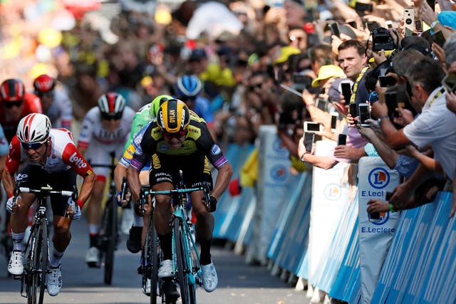Fans lean over to photograph the Tour de France riders