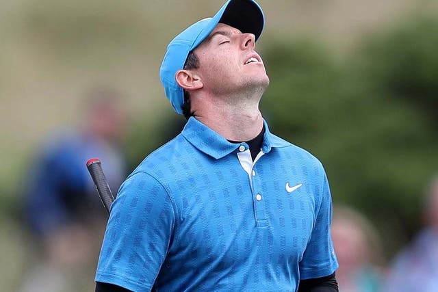 Rory McIlroy reacts after scoring a triple-bogey on his final hole to finish the day eight-over-par