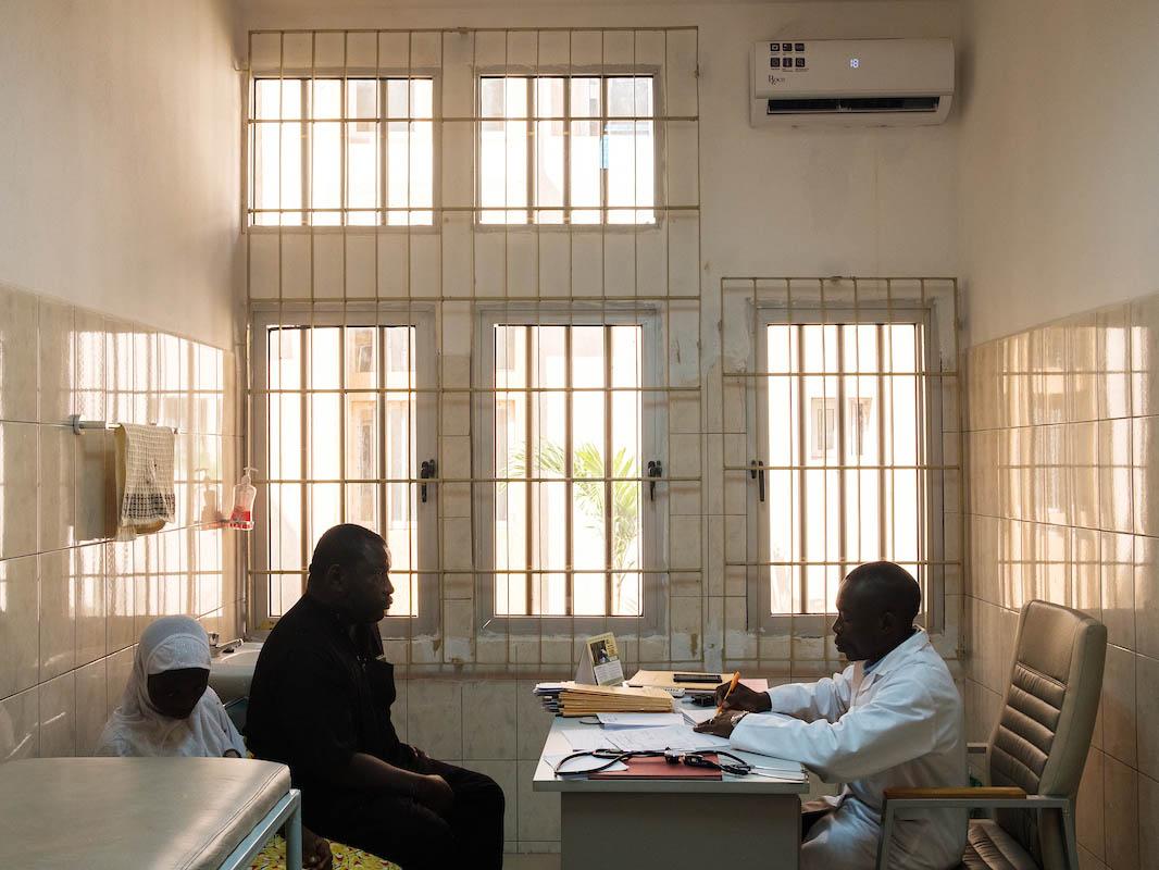 Nassibatou, 13, and her father Yaminou, during a consultation with Dr Magnang. Nassibatou is having a sickle-cell-related vaso-occlusive crisis