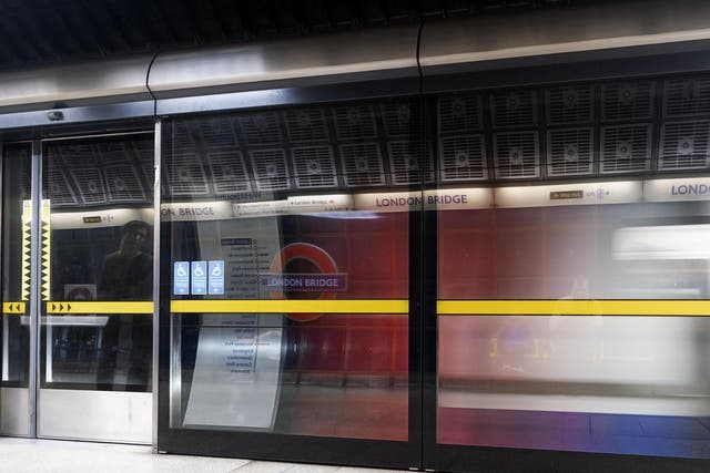 A Jubilee Line London Underground train is speeding out of the station