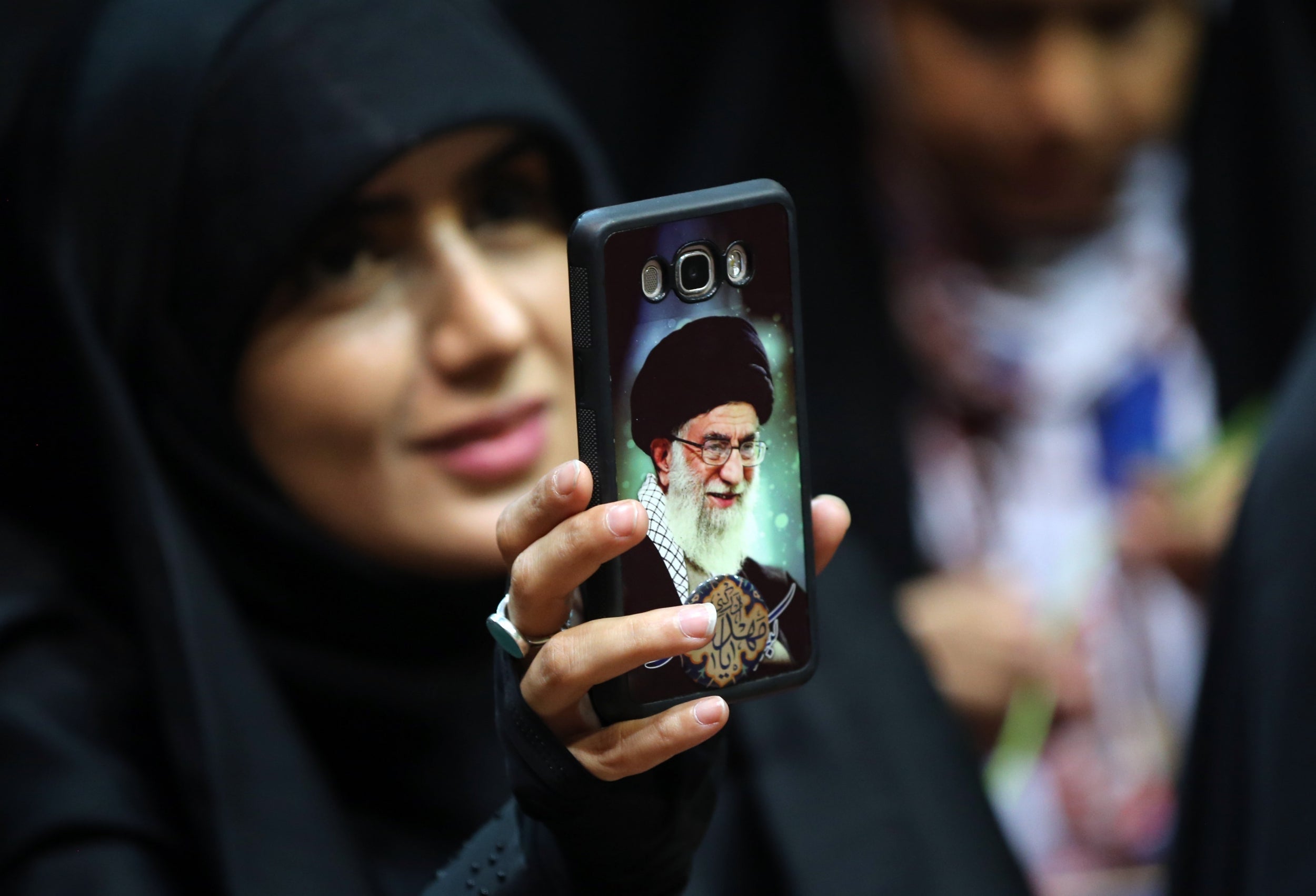 An Iranian woman shows her phone cover depicting Khamenei (AFP/Getty)