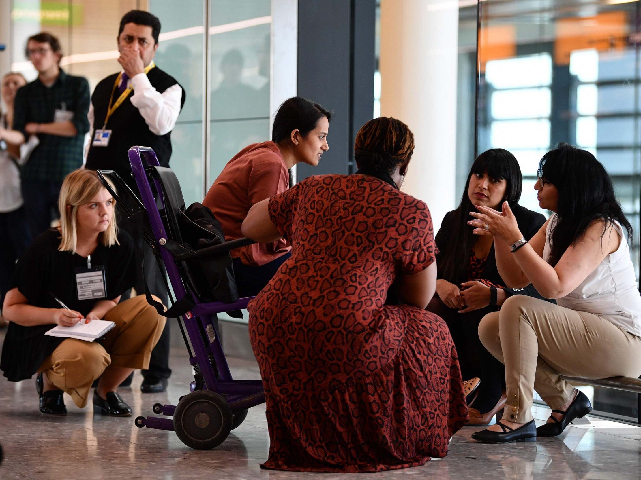 A family is asked questions by officials after landing from Bangalore in India, in Terminal 2 at Heathrow Airport in London on 16 July, as part of Operation Limelight (AFP/Getty)