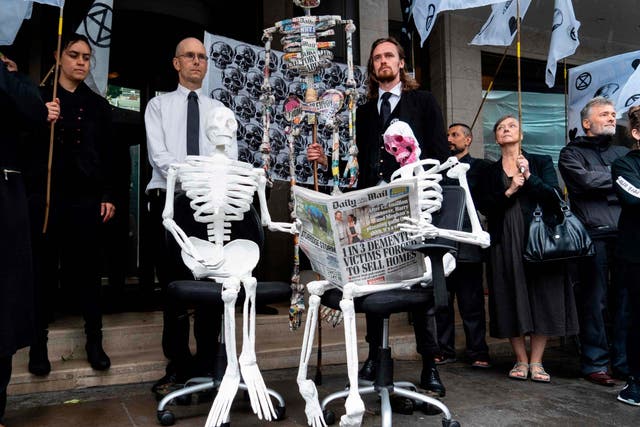 Demonstrators from the Extinction Rebellion climate environmental activist group take part in a protest outside the offices of UK newspapers including the Daily Mail at Northcliffe House in West London