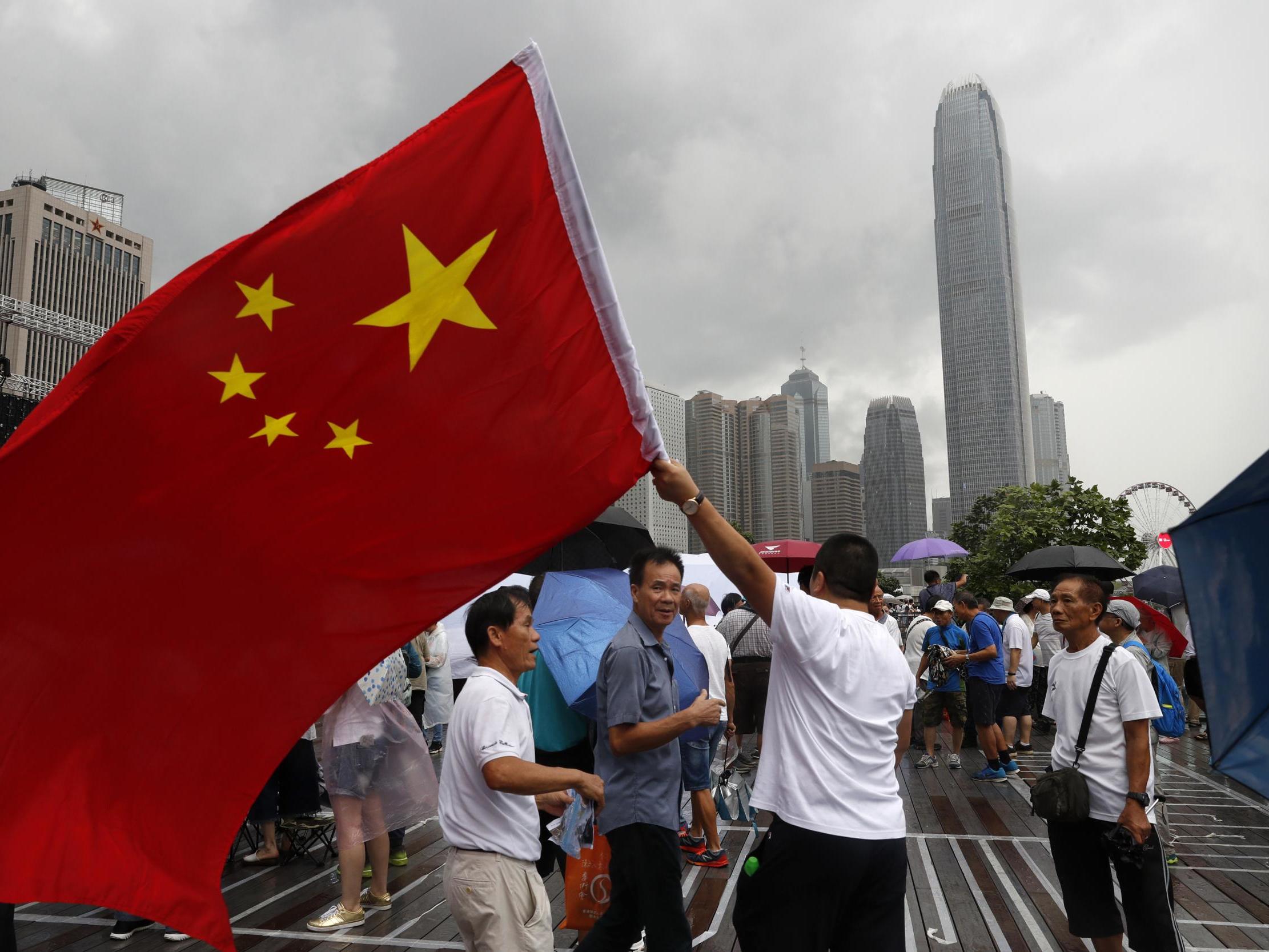 A pro-China supporter waves a Chinese national flag during a counter-rally in support of the police in Hong Kong on Saturday 20 July 2019.