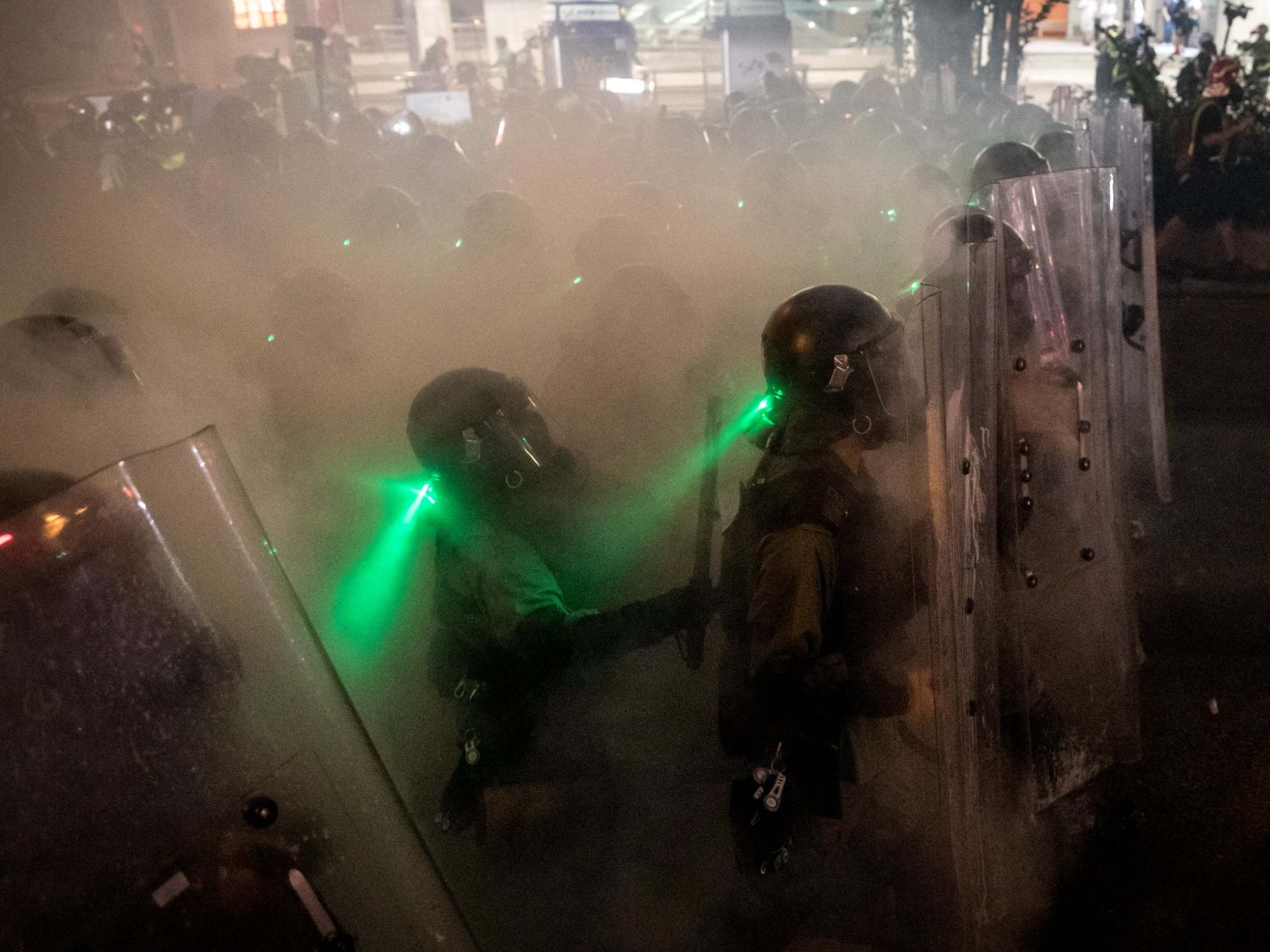 Police move forward through tear gas as they clash with protesters (Chris McGrath/Getty)