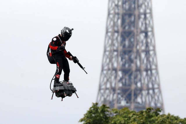 Franky Zapata flies on a Flyboard near the Eiffel Tower during the traditional Bastille Day military parade on the Champs-Elysees Avenue in Paris