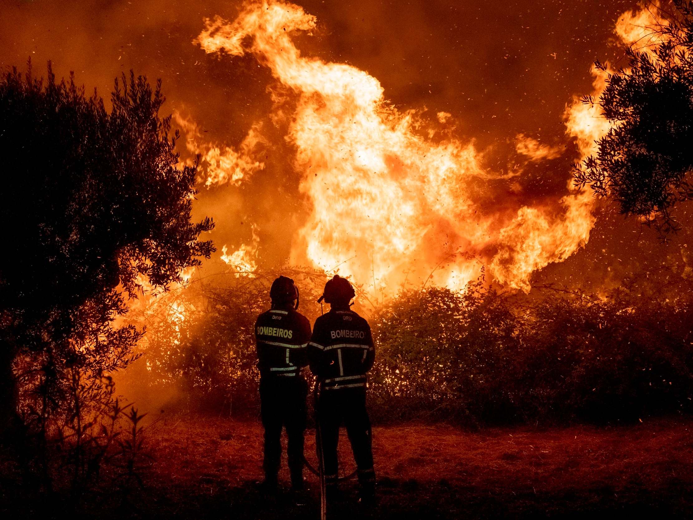 Fighters try to extinguish a wildfire near Cardigos village, in central Portugal on Sunday, July 21, 2019