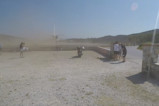 A departing plane kicks up a cloud of dust at Skiathos airport