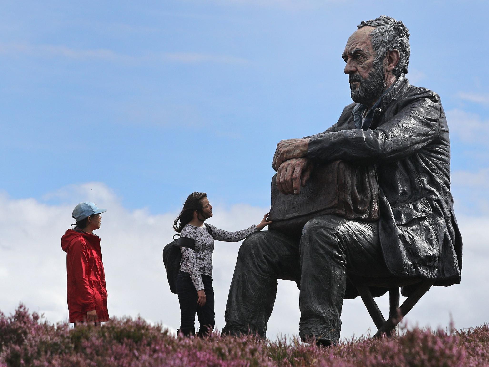 Tourists visit Sean Henry's Seated Figure on the North York Moors in 2017