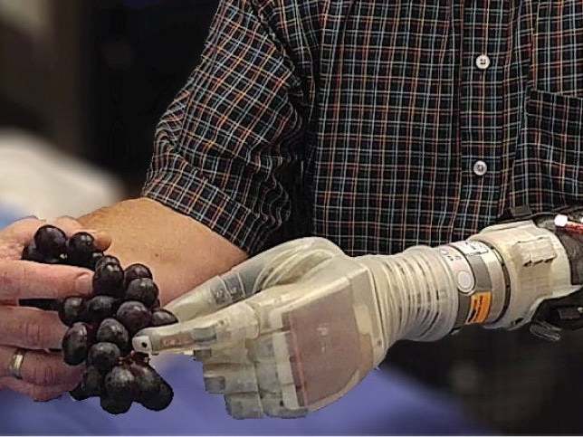 Keven Walgamott tests a robotic arm which can give amputees the sensation of touch through sensors in the hand, making it easier to pick up and hold objects