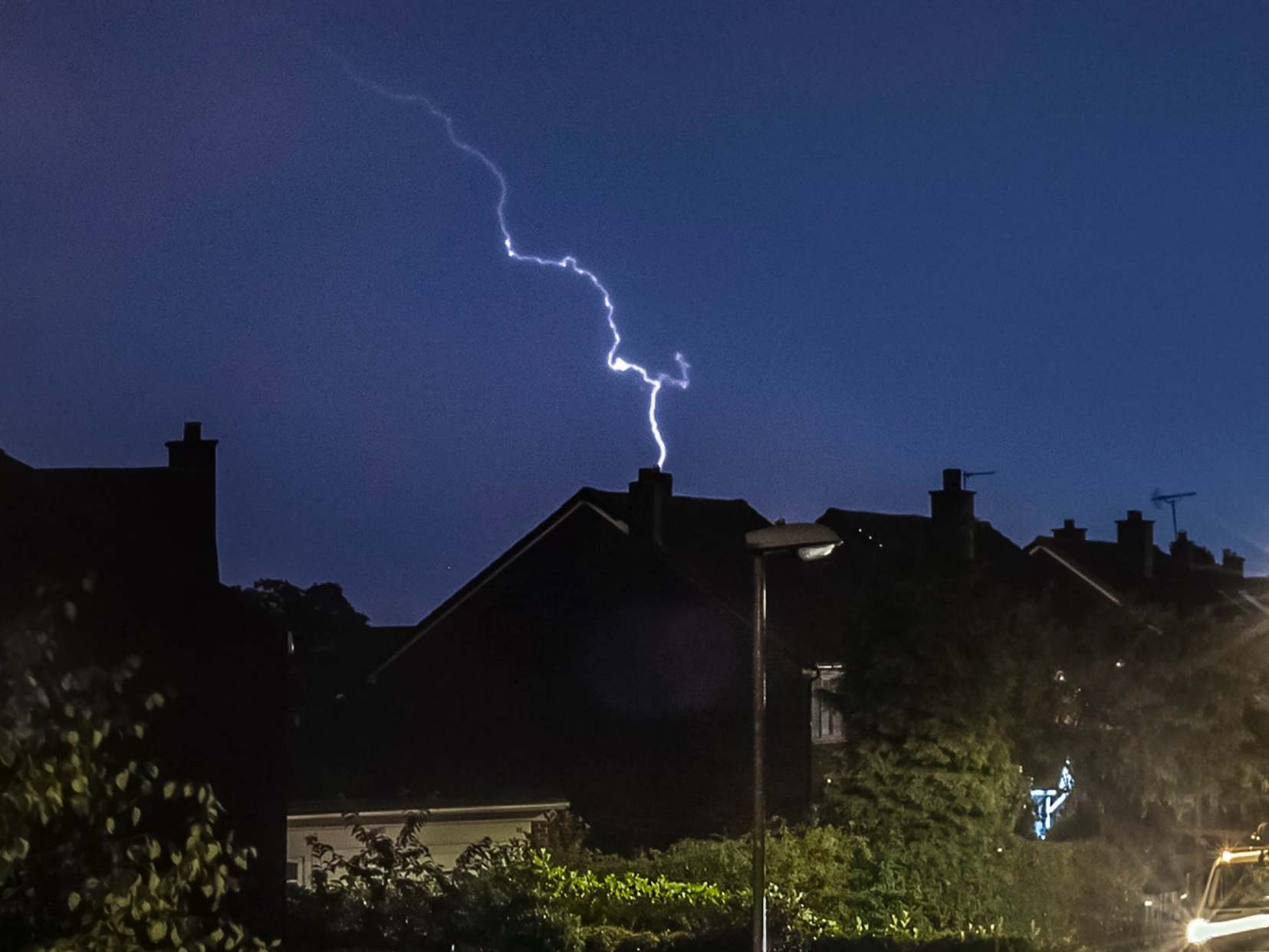 Lightning strikes as a thunder storm passes over houses in Leeds (PA)