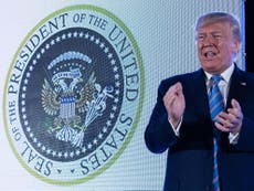 Trump speaks in front of fake seal with Russian eagles and golf clubs