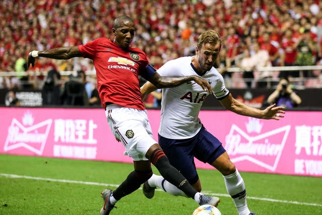 Harry Kane of Tottenham Hotspur competes for the ball with Ashley Young