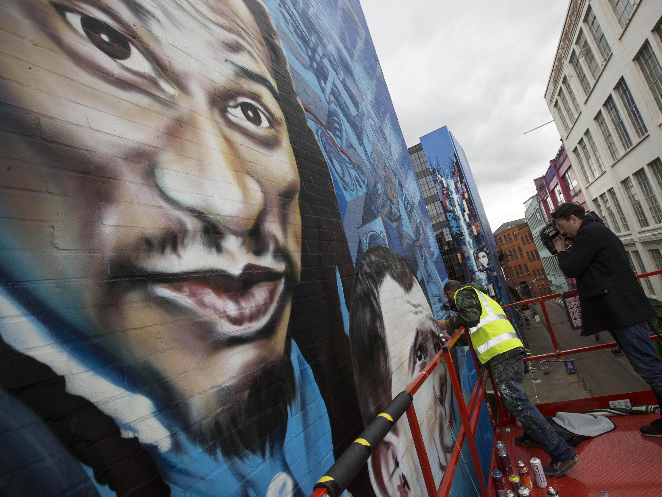 A six-storey-high mural of Birmingham-born luminaries Benjamin Zephaniah, Mike Skinner, Lady Leshurr and Felicity Jones outside the Custard Factory (PA)