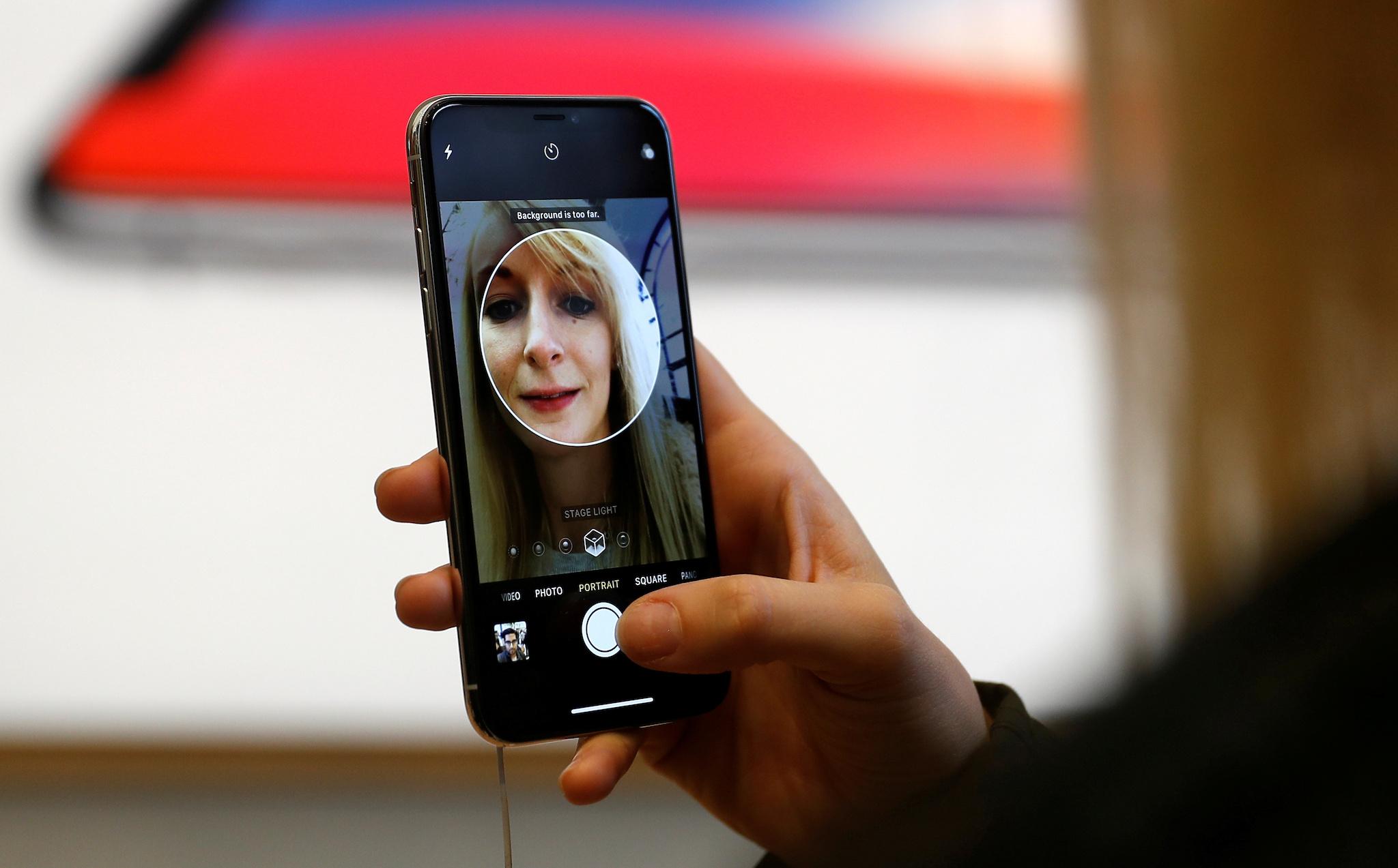 A customer uses the new face-recognition software on the new iPhone X inside the Apple Store in Regents Street in London