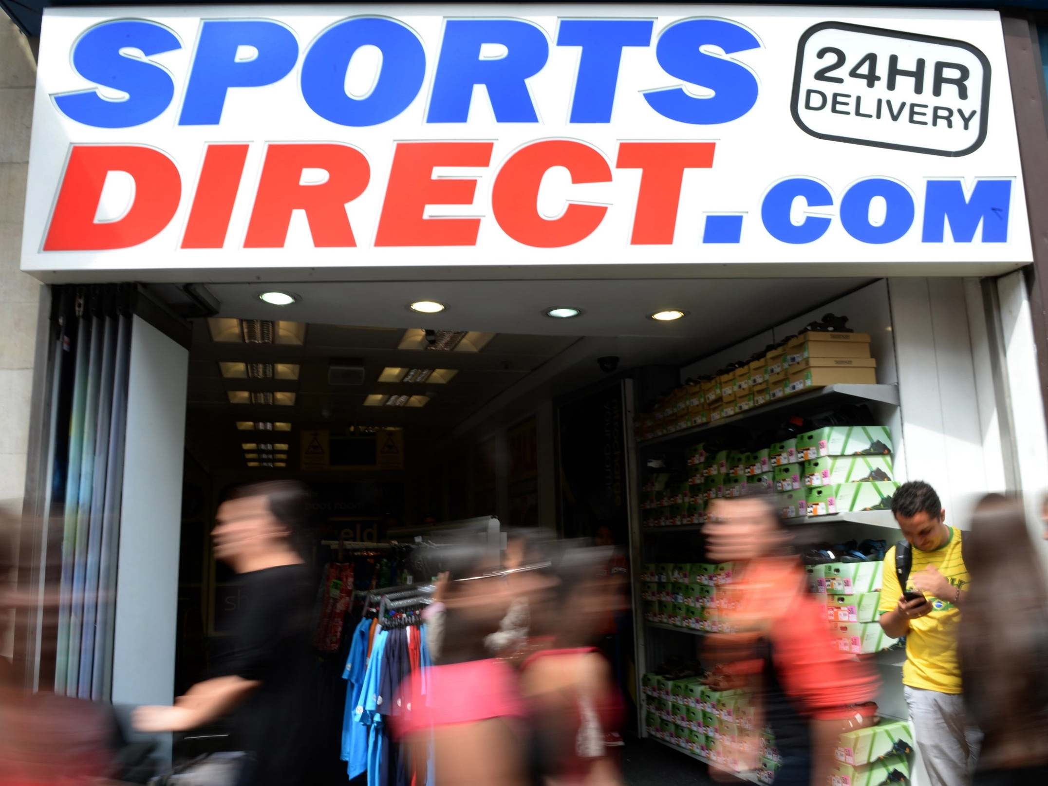 Pedestrians pass a Sports Direct store in central London
