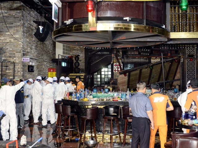 Firefighters and officials examine the collapsed structure of the Coyote Ugly nightclub where several athletes competing at the World Swimming Championships were dancing in the city of Gwangju in South Korea