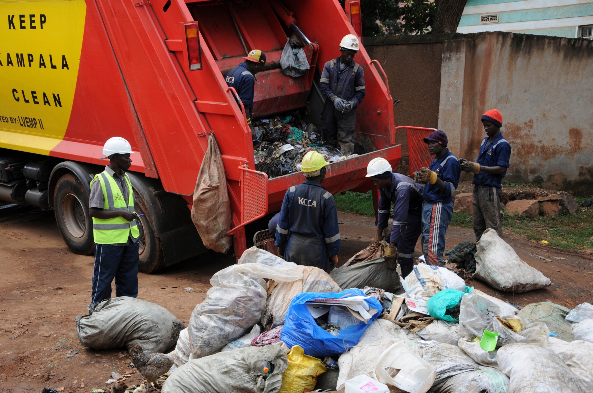 Workers of Kampala Capital City Authority remove waste under a campaign encouraging people to keep their neighbourhood clean