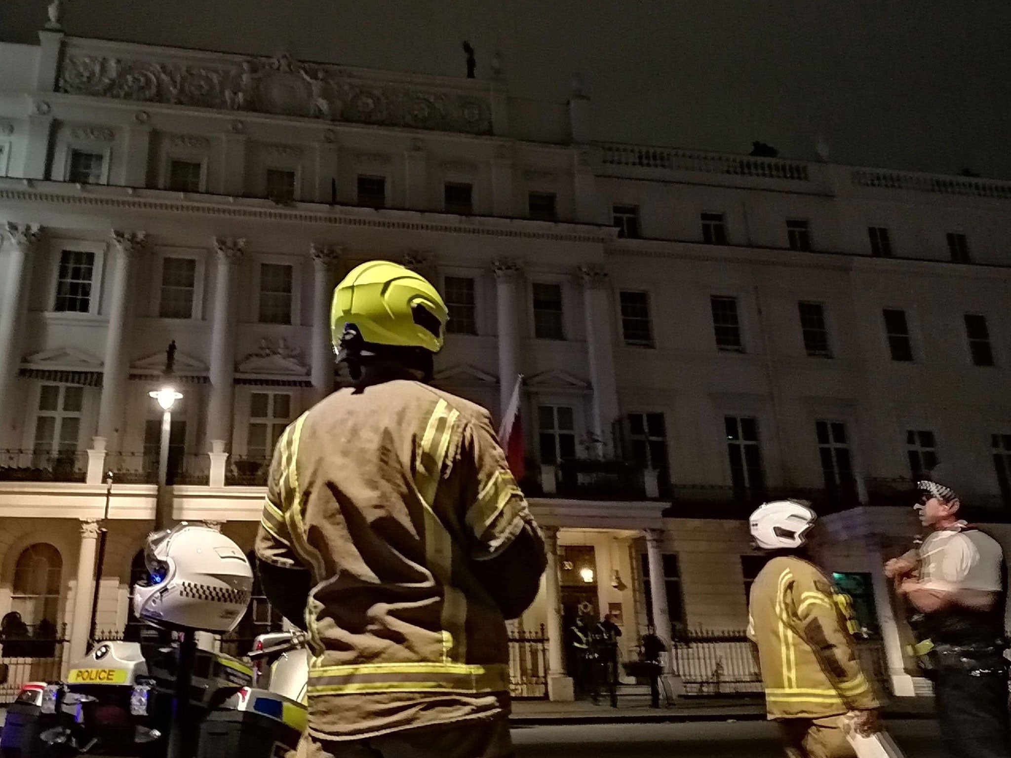 Firefighters and police outside the Bahrain embassy in London’s Belgrave Square as a man protests on the roof on 26 July