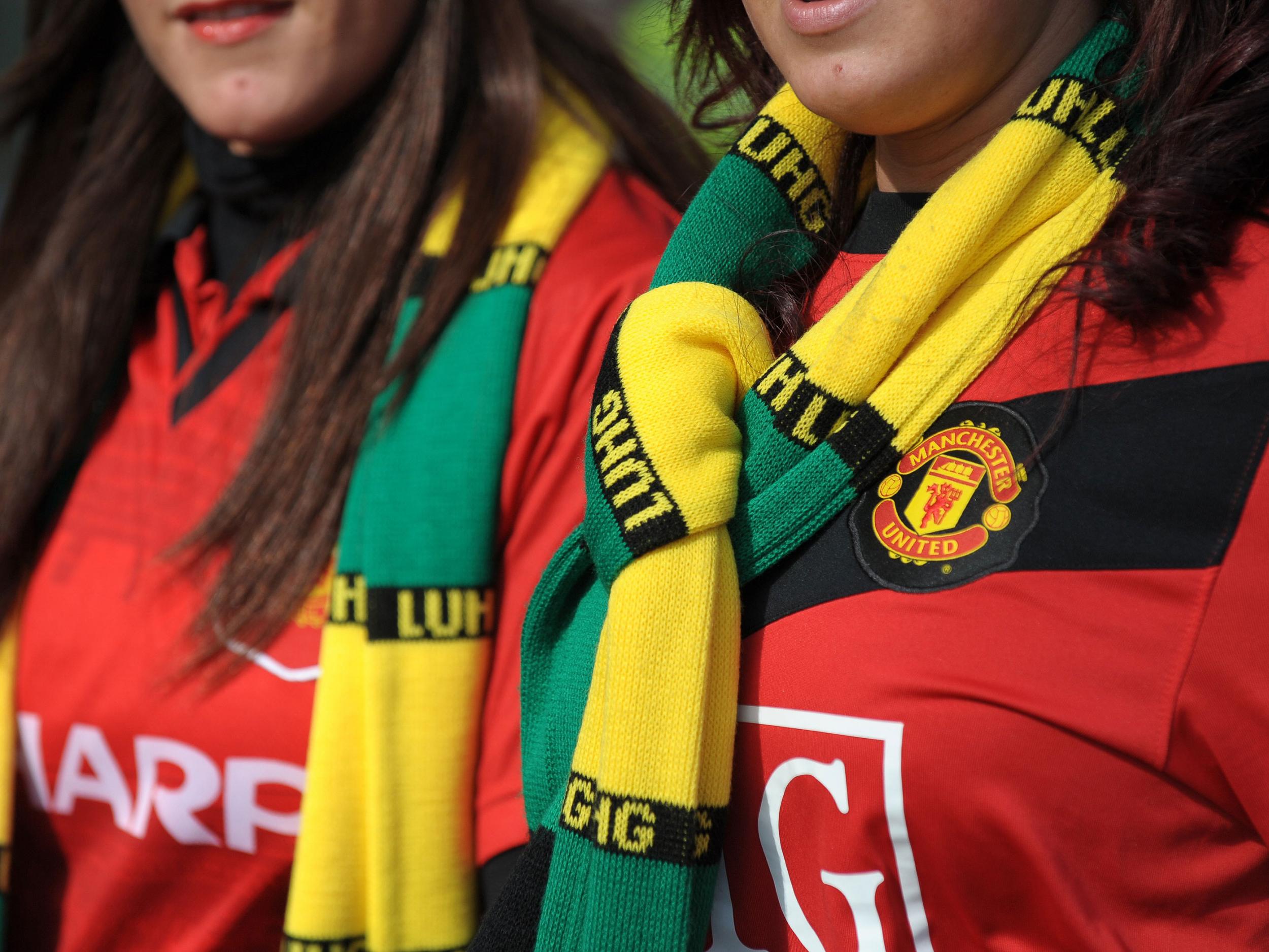 Manchester United fans wearing green and gold scarves
