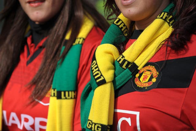 Manchester United fans wearing green and gold scarves