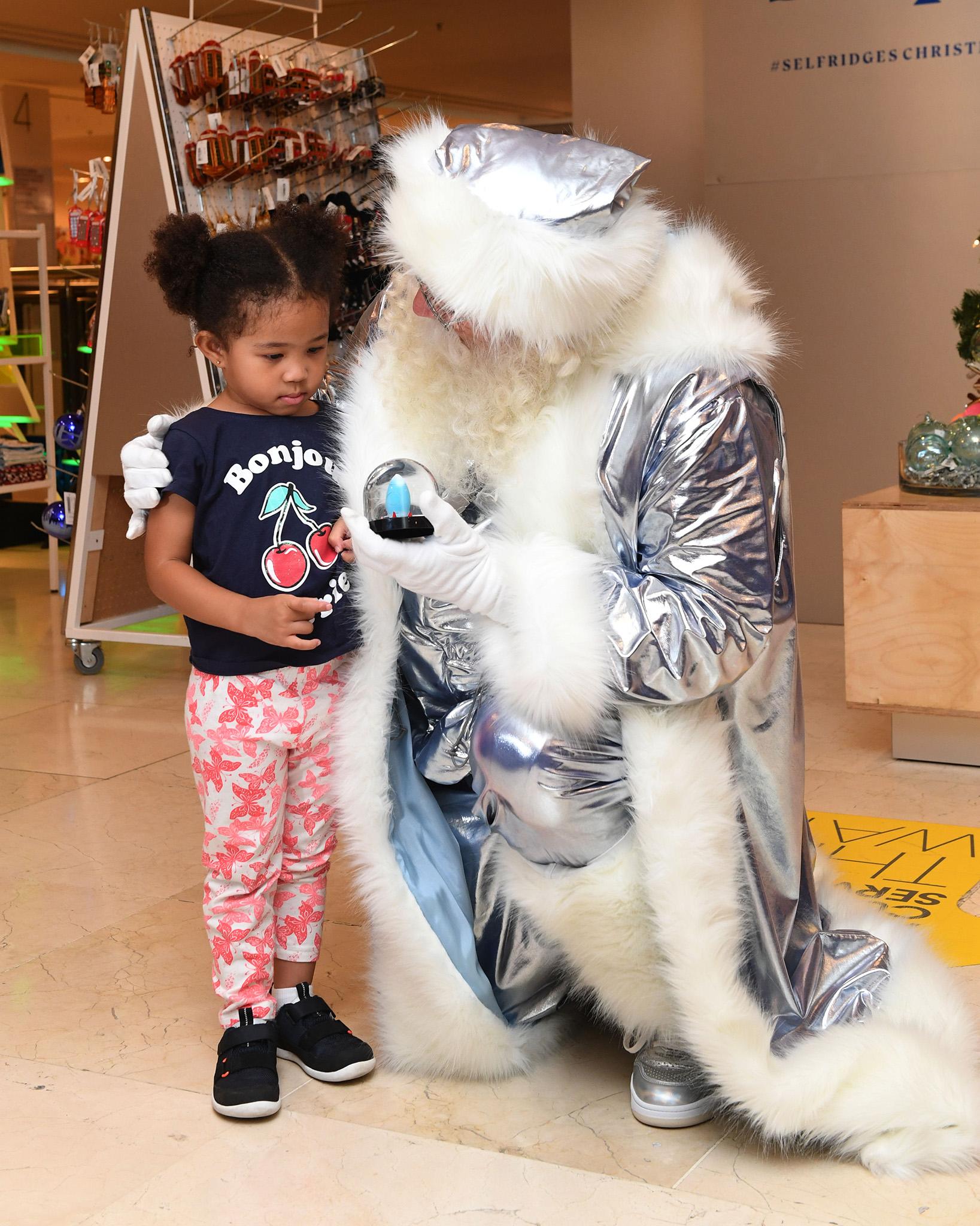 "Future fantasy" Father Christmas offers a gift to a child in the Selfridges Christmas shop in London on July 29