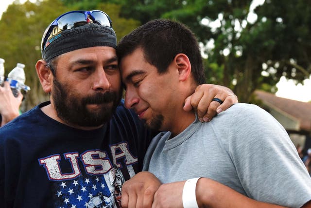 Justin Bates (right), a survivor of the mass shooting, is comforted by his father Rob at a vigil in Gilroy