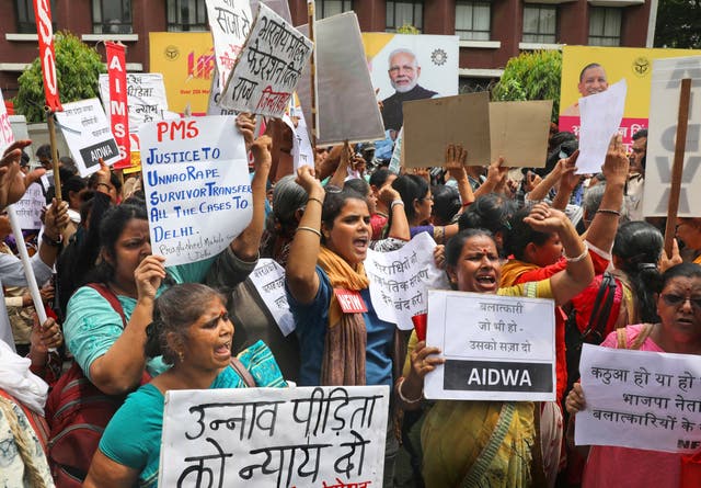 Activists in Delhi shout slogans during a protest demanding a fast-track probe into a highway accident that critically injured a woman who has accused a ruling BJP politician of rape