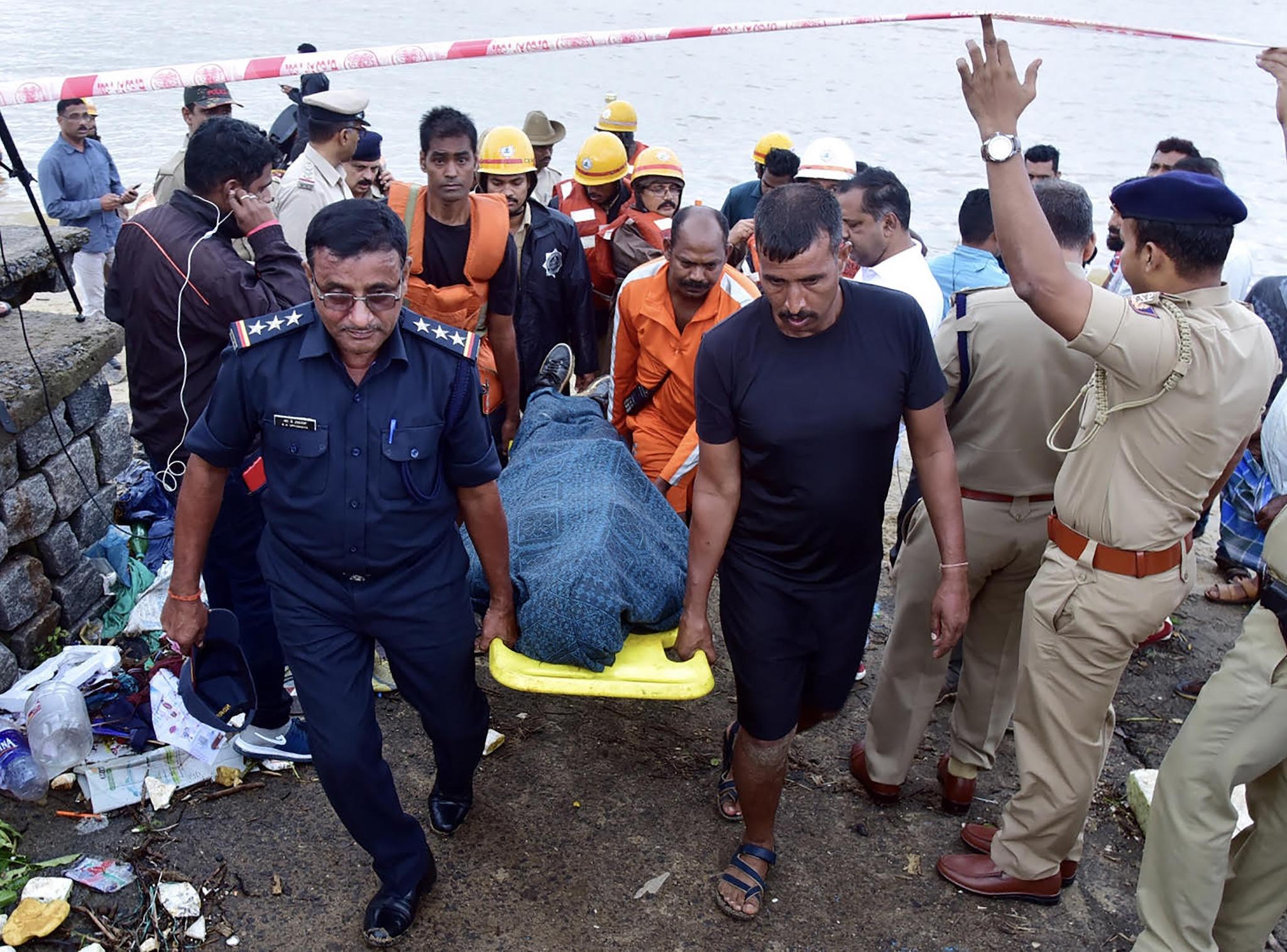 National Disaster Response Force (NDRF) personnel carry the body of missing Indian coffee tycoon V G Siddhartha from the banks of the Netravati river towards a waiting ambulance on Wednesday