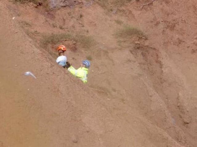 Owen Scrimshaw, of HM Coastguard, rescues a man and a woman at Filey Brigg