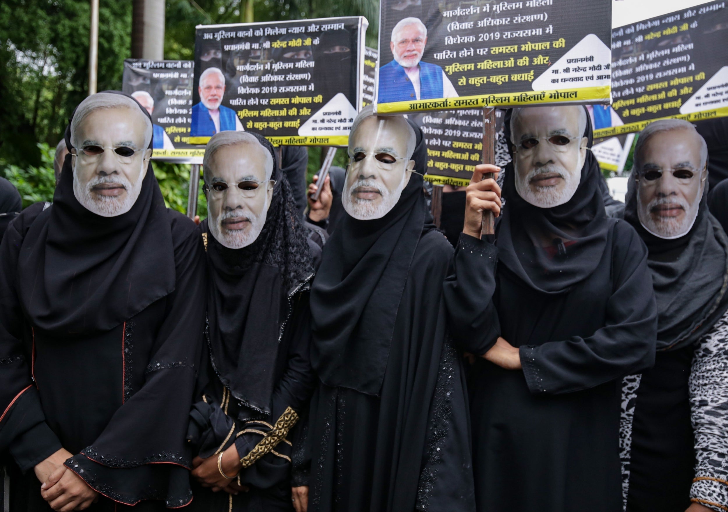 Muslim women wearing face masks of Indian Prime Minister Narendra Modi take part in an event organised by the BJP to celebrate the passage of a law to outlaw triple talaq