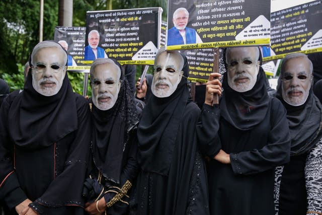 Muslim women wearing face masks of Indian Prime Minister Narendra Modi take part in an event organised by the BJP to celebrate the passage of a law to outlaw triple talaq