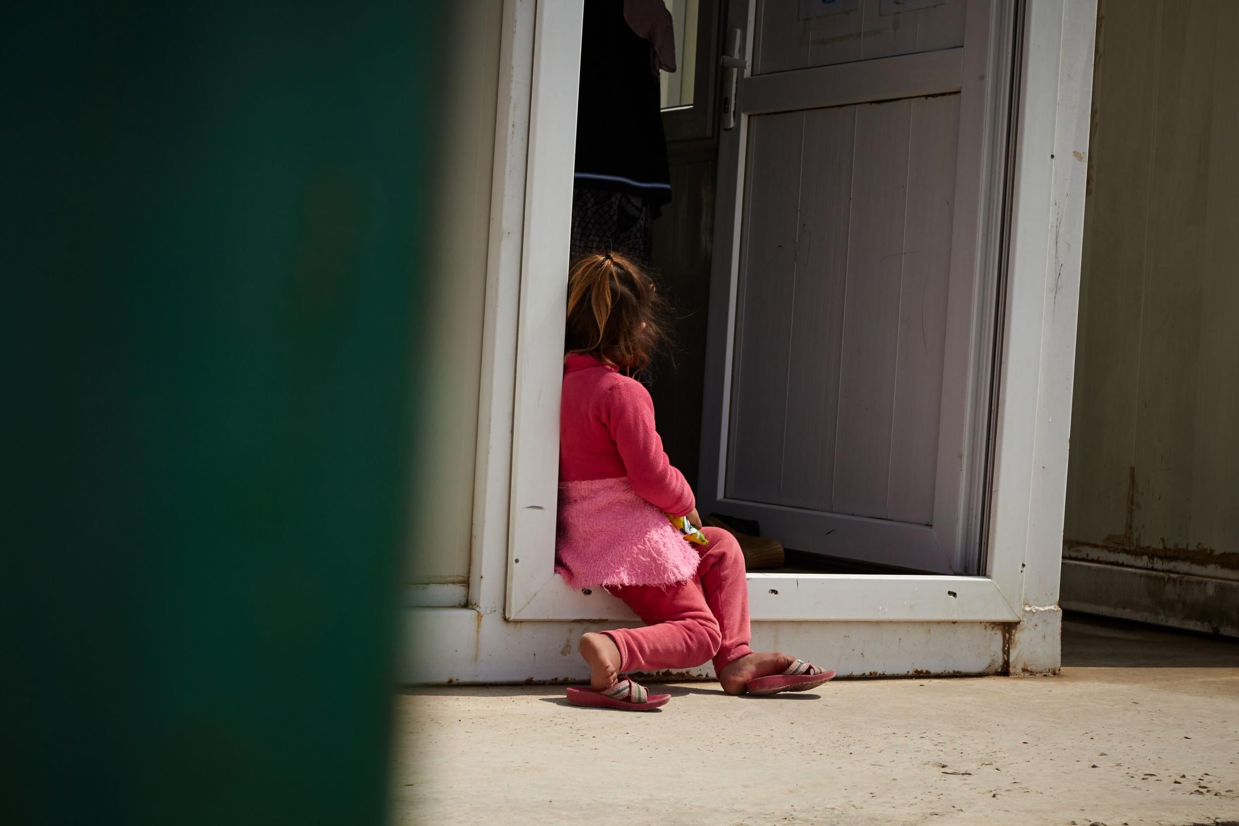 A young girl sits outside the women’s centre at a camp in Dohuk in the Kurdish region of Iraq