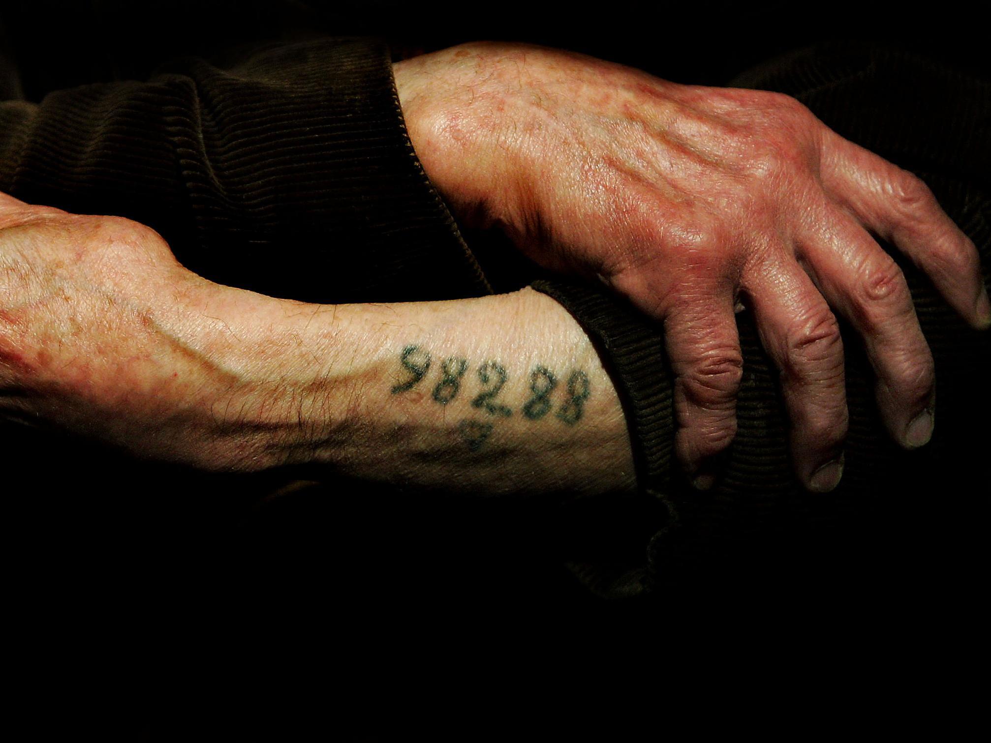 Auschwitz survivor Leon Greenman displays his number tattoo at the Jewish Museum in London, England