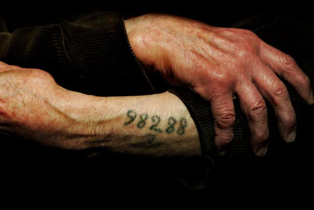 Auschwitz survivor Mr. Leon Greenman, prison number 98288, displays his number tattoo on December 9, 2004 at the Jewish Museum in London, England.