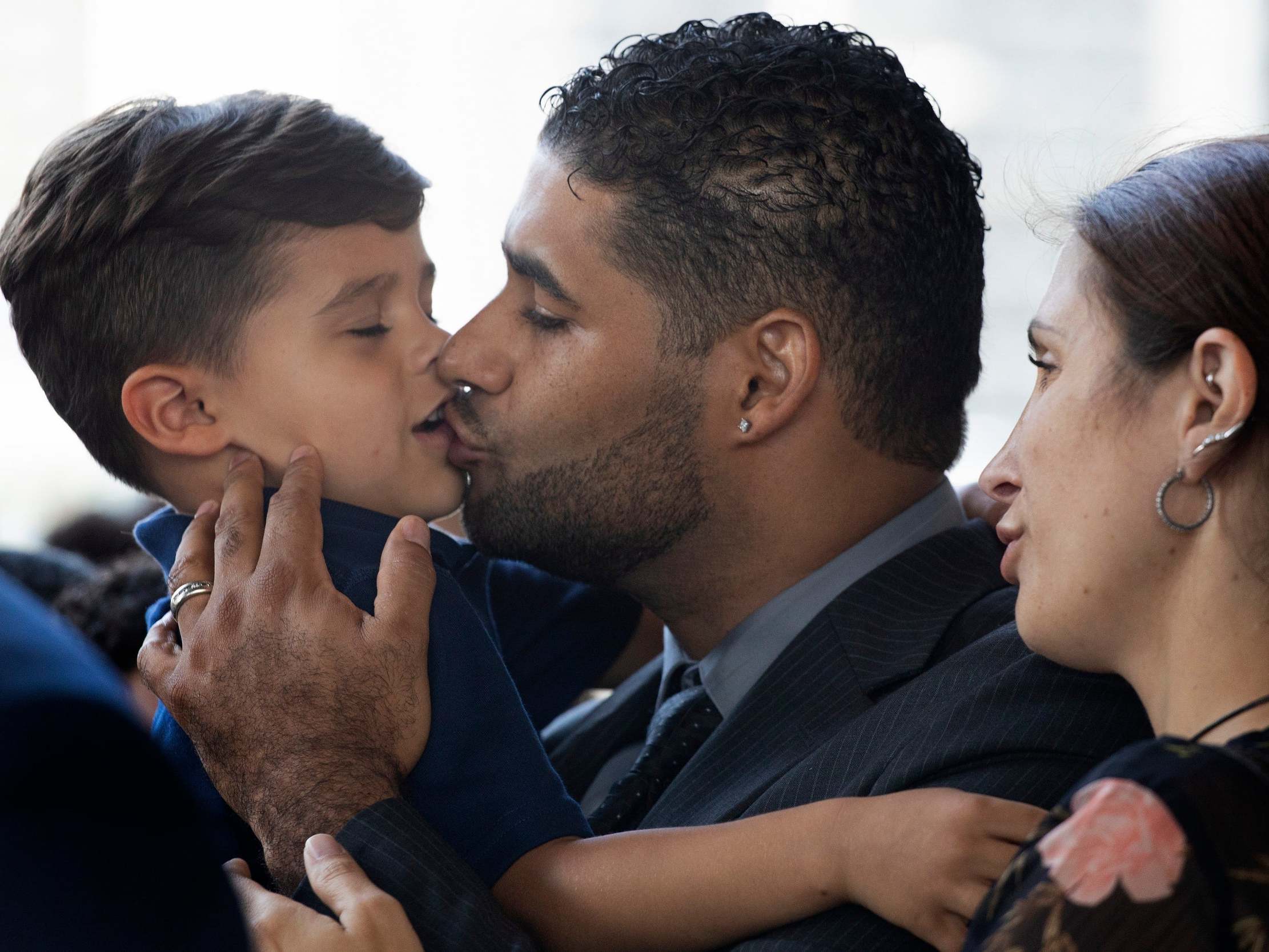 Left twin. Dad kissing their son.