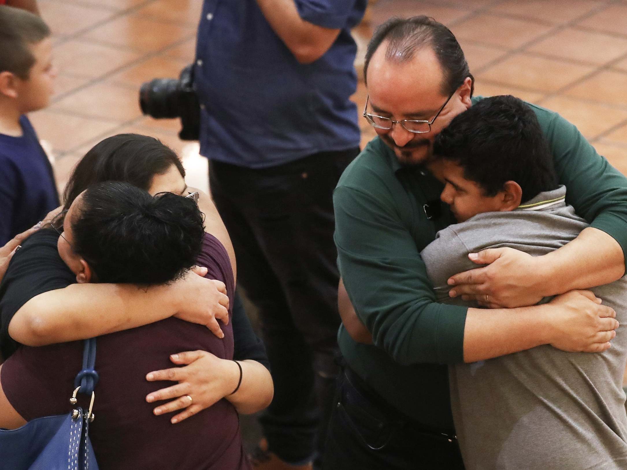 People hug at a vigil for victims of the shootings, which left 20 people dead and dozens wounded