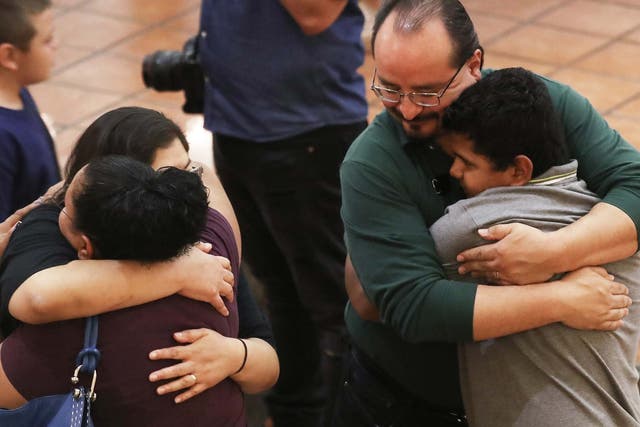 People hug at a vigil for victims of the shootings, which left 20 people dead and dozens wounded