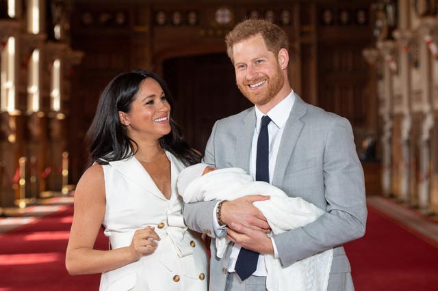 Prince Harry, Duke of Sussex and Meghan, Duchess of Sussex, pose with their newborn son Archie Harrison Mountbatten-Windsor during a photocall in St George's Hall at Windsor Castle on May 8, 2019 in Windsor, England
